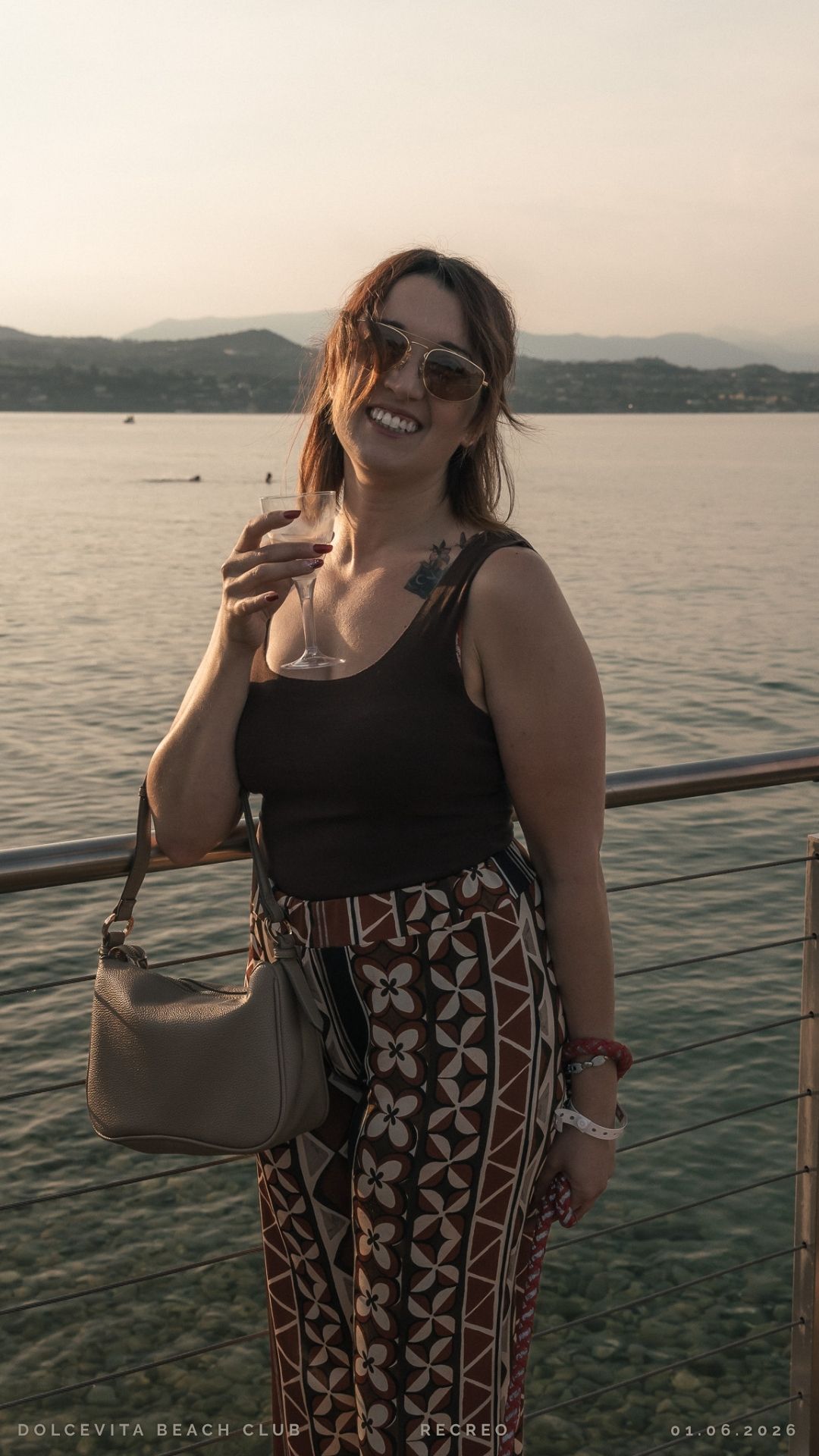 Ospite con calice vista lago al tramonto