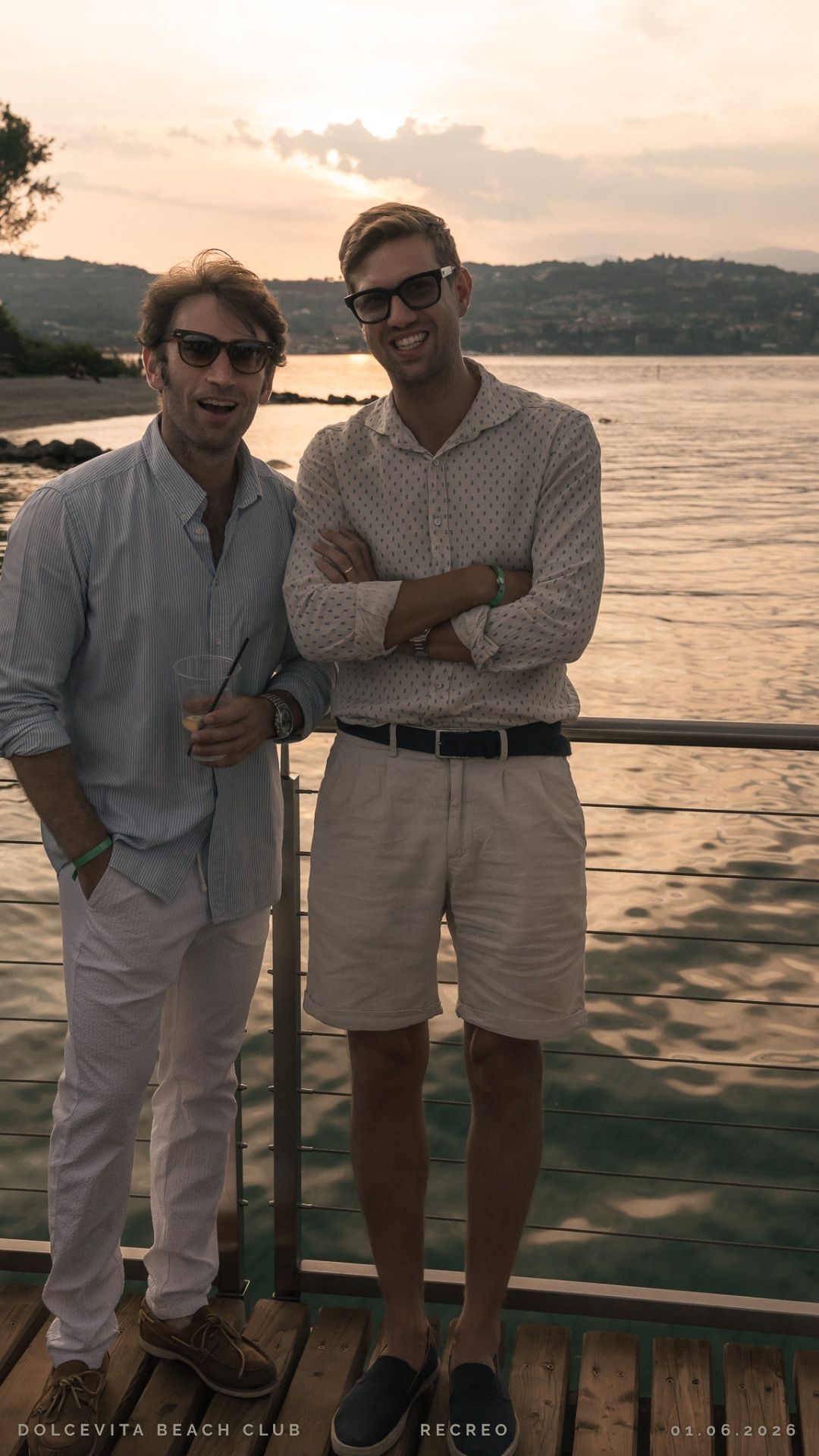 Due amici posano sul pontile al tramonto