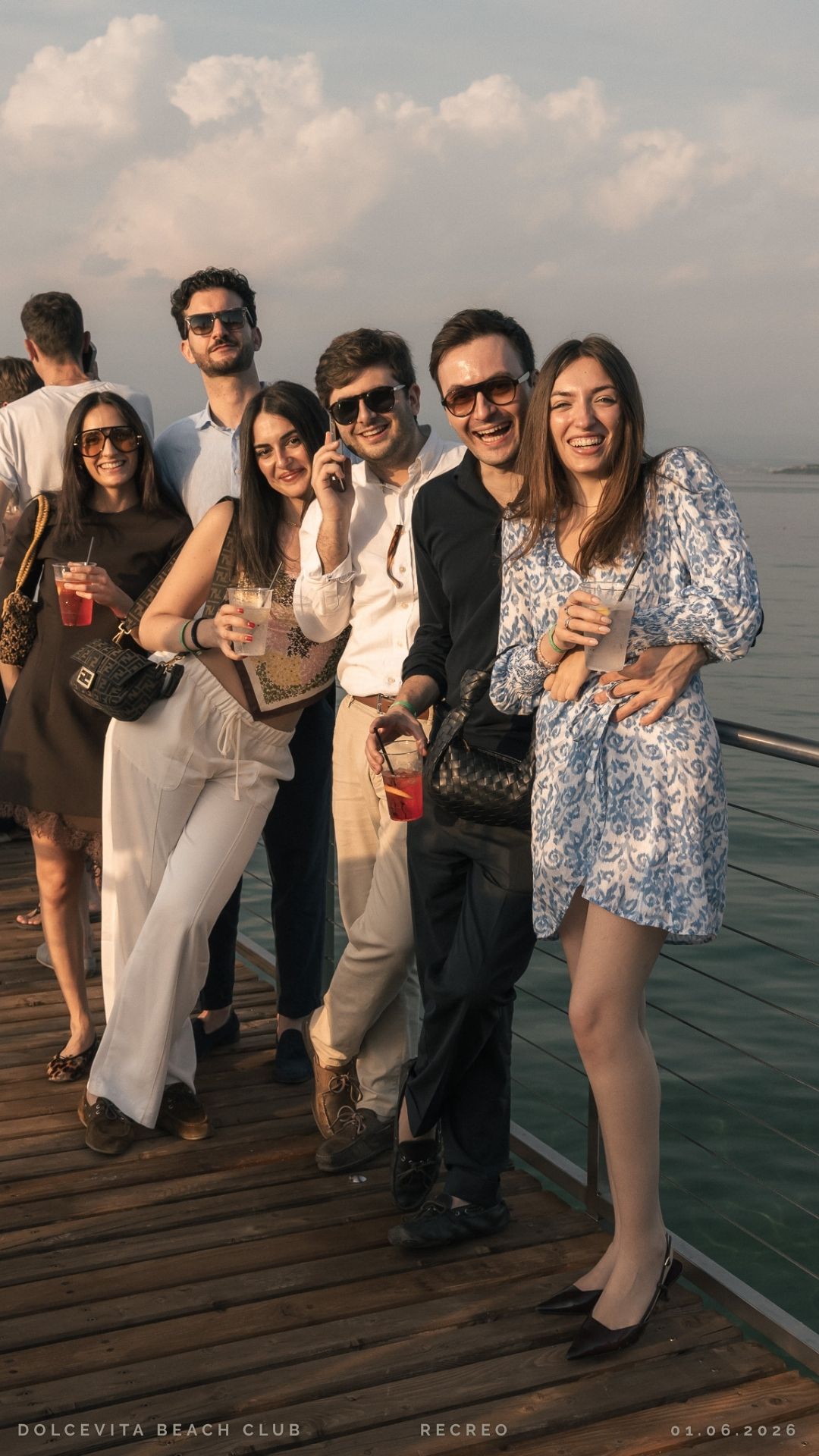 Gruppo di amici sulla passerella con drink