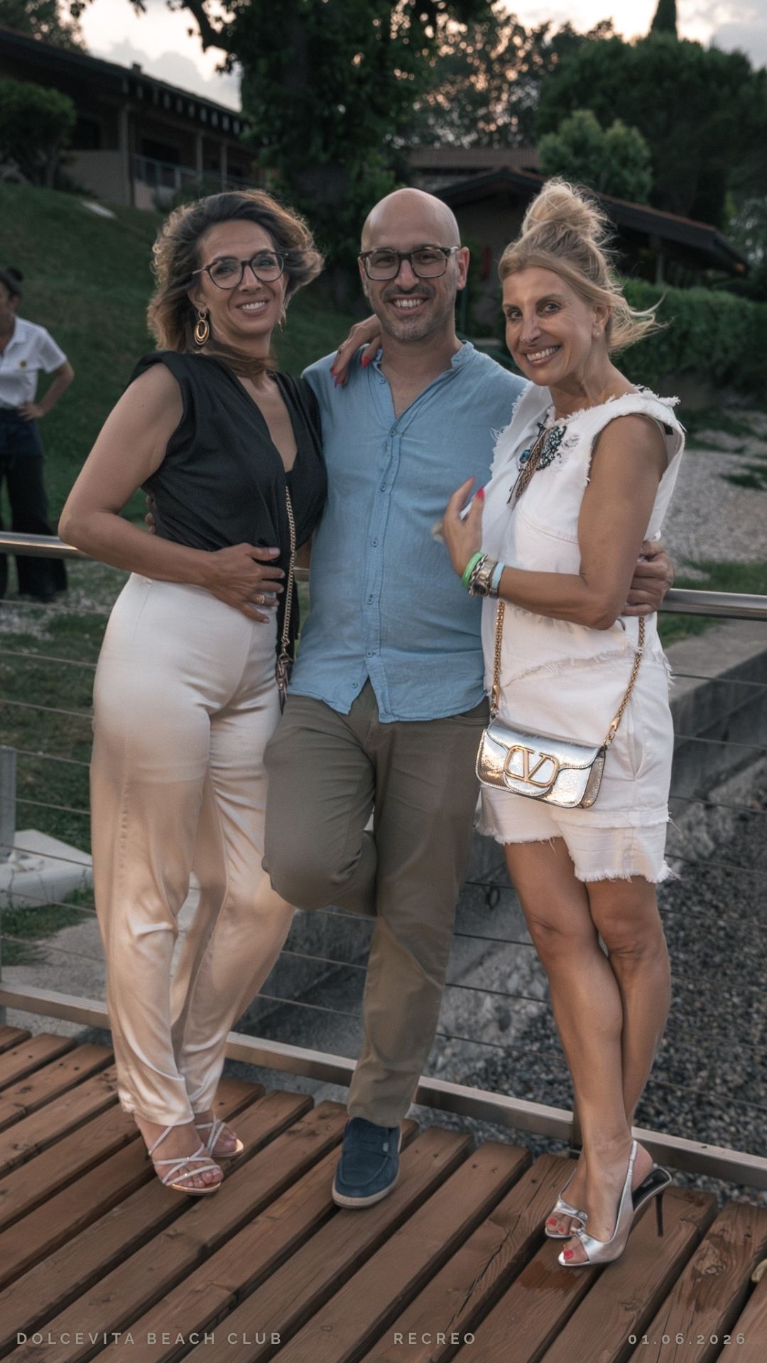 Tre amici posano sorridenti al tramonto