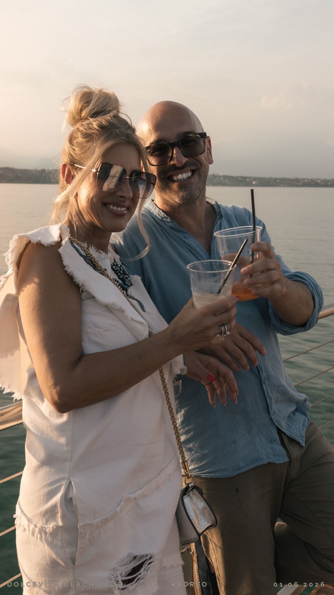 Coppia brinda con cocktail vista lago