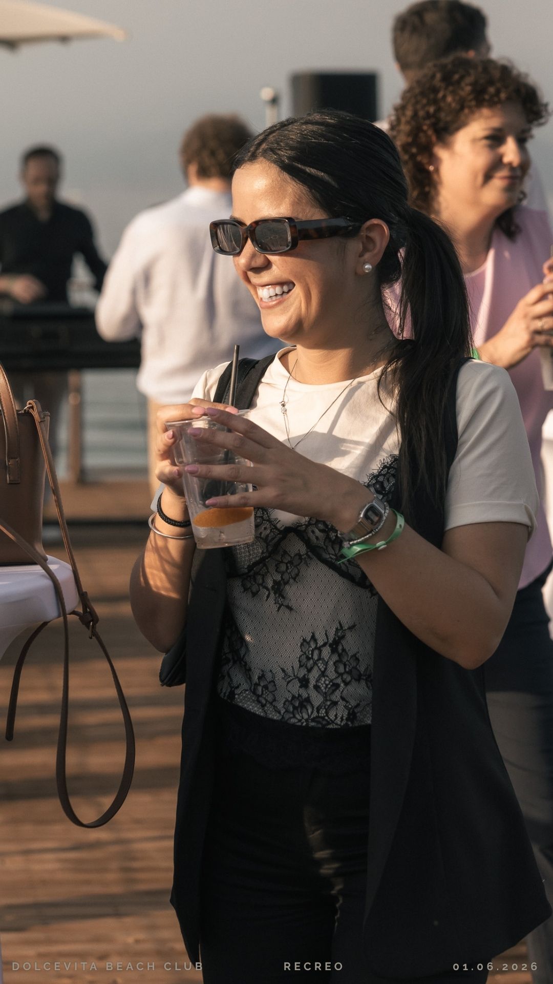 Ospite sorridente con drink durante il sunset