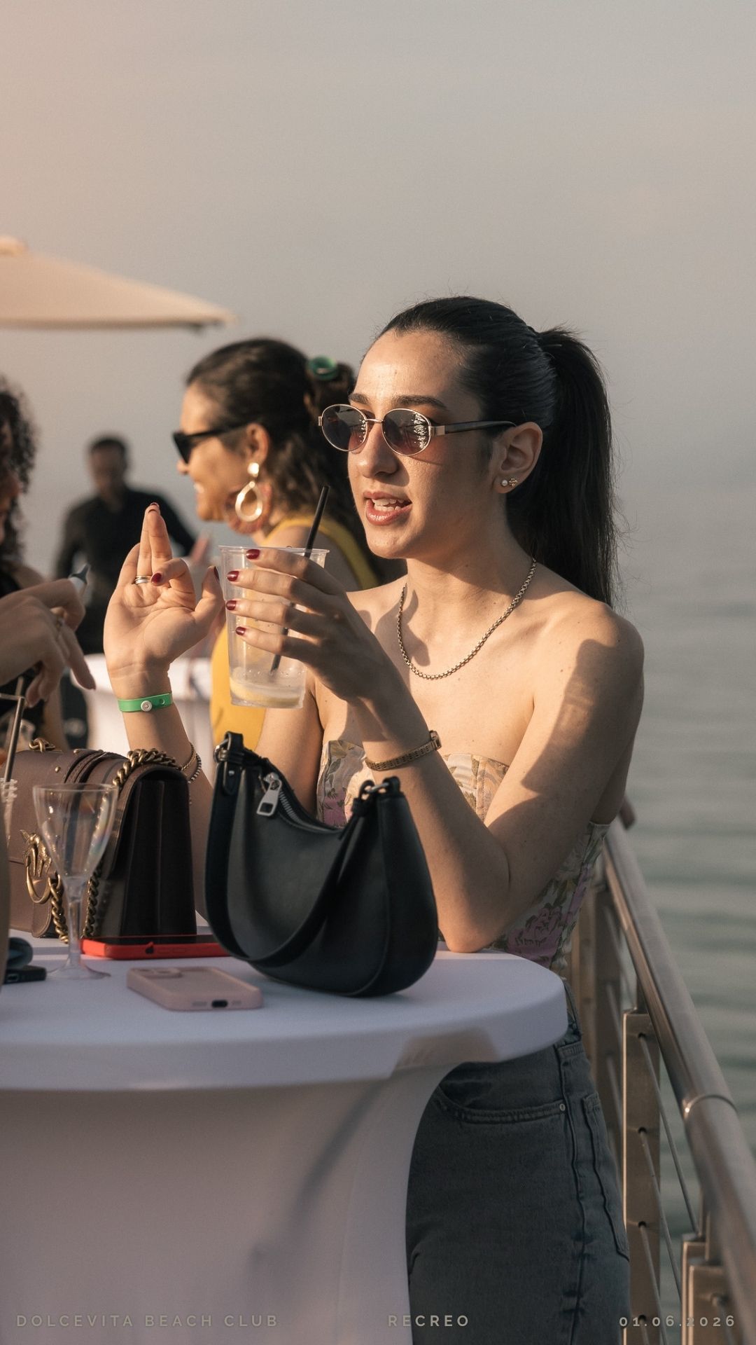 Ospite con cocktail al tavolo vista lago
