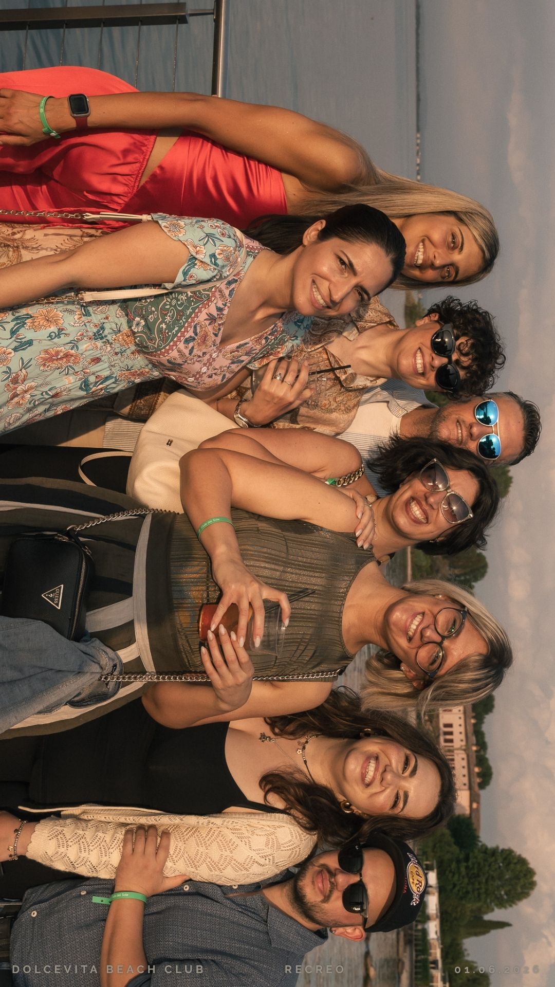 Gruppo di amici posa sorridente al tramonto